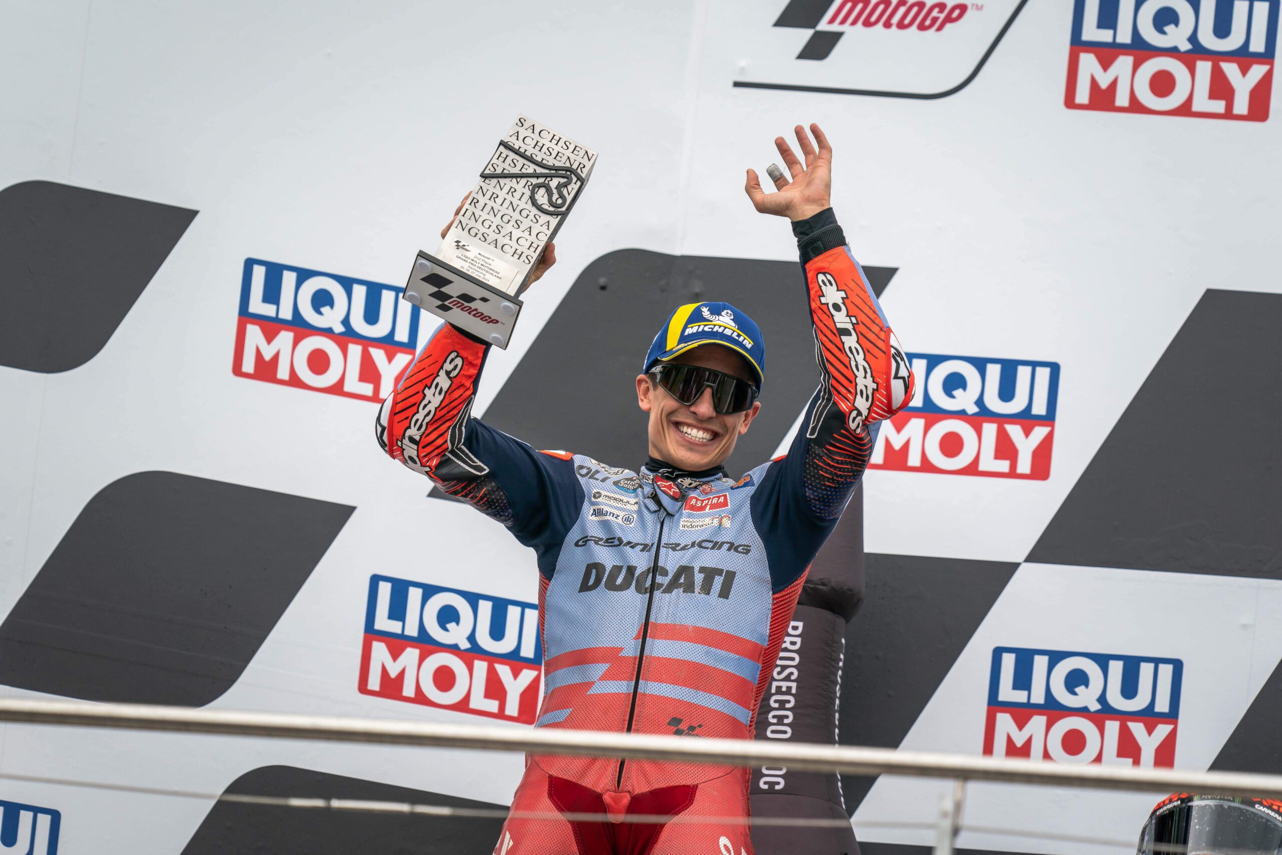 Jubelnd hält Zweitplatzierter der MOTOGP Marc Marquez auf dem Siegerpodium seinen Pokal in die Höhe