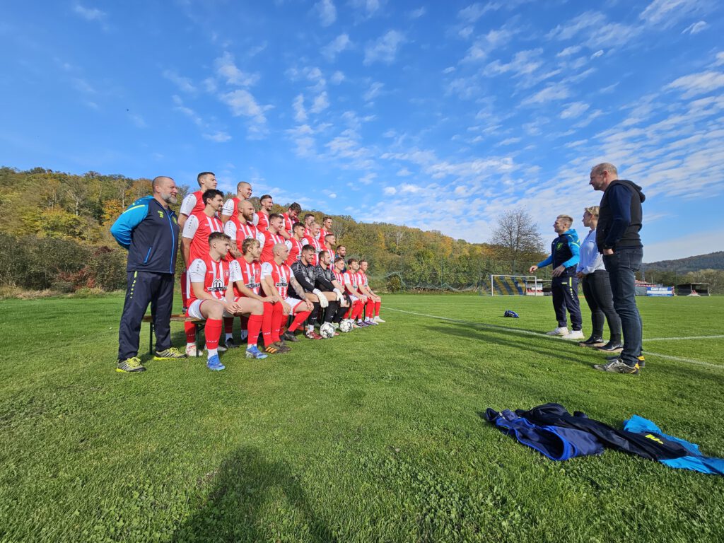 Seitenansicht des Fußballteams, Trainers und der Oganisateure