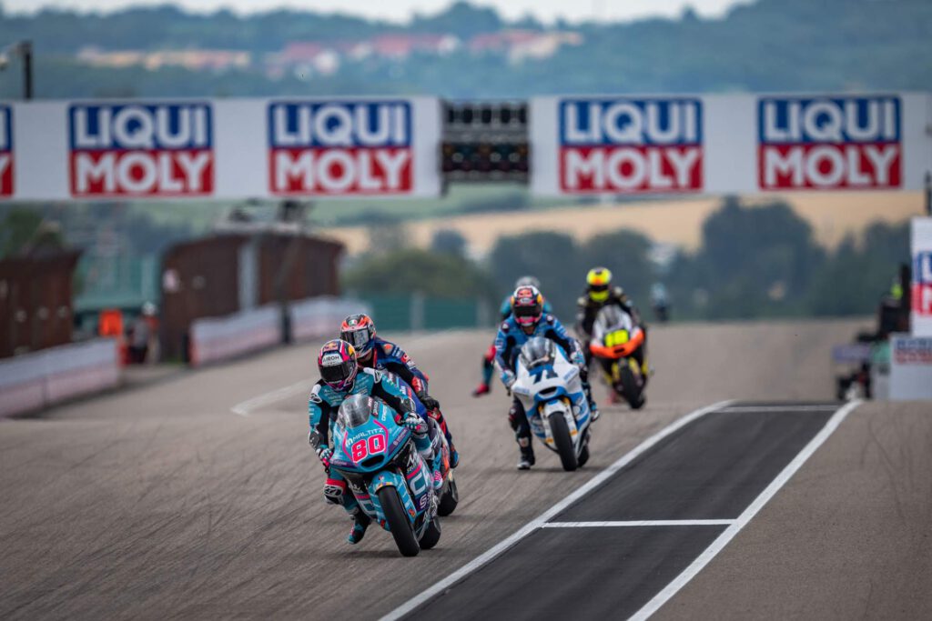 4 Motorradfahrer vor der Kulisse von bannern des Liqui Moly Veranstalters