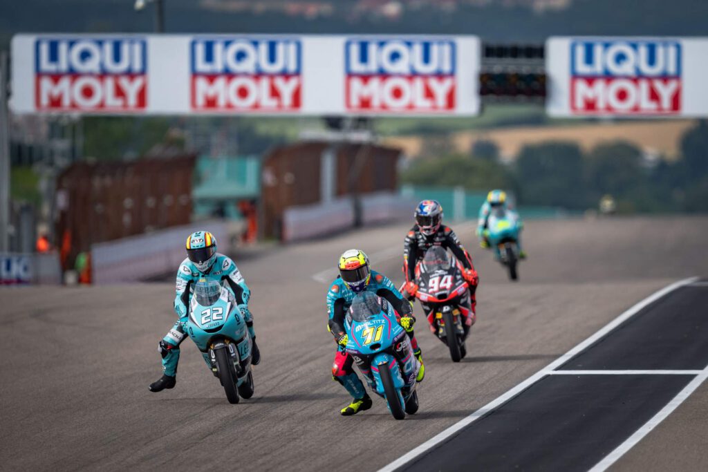 4 Motorradfahrer vor der Kulisse von bannern des Liqui Moly Veranstalters