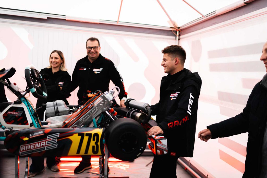Nils Tröger an einem aufgebocktem Kart im Zelt vor der Rennstrecke, dahinter Susann Urlaß-Wolf und Roberto Urlaß