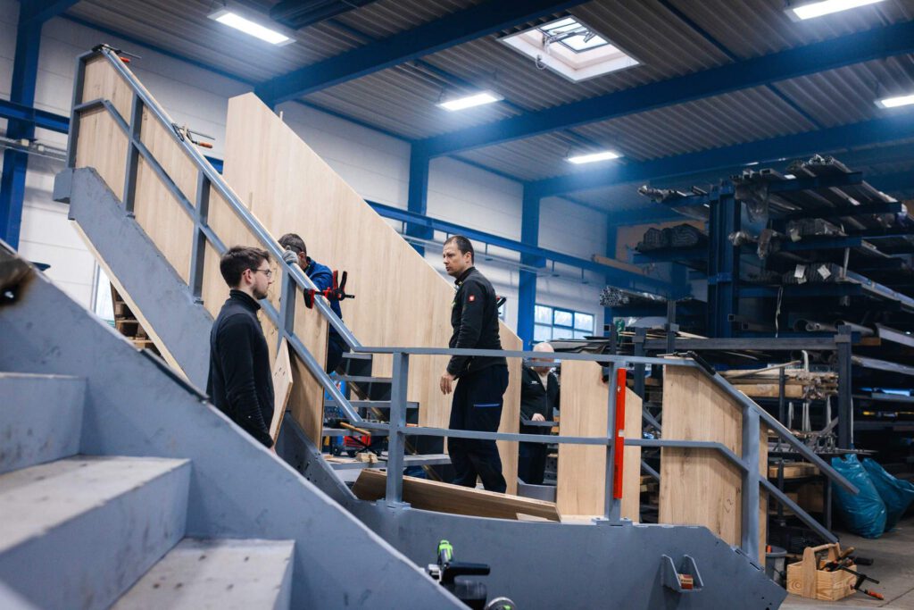 Mitarbeiter beim Bau der Treppe in der Werkhalle