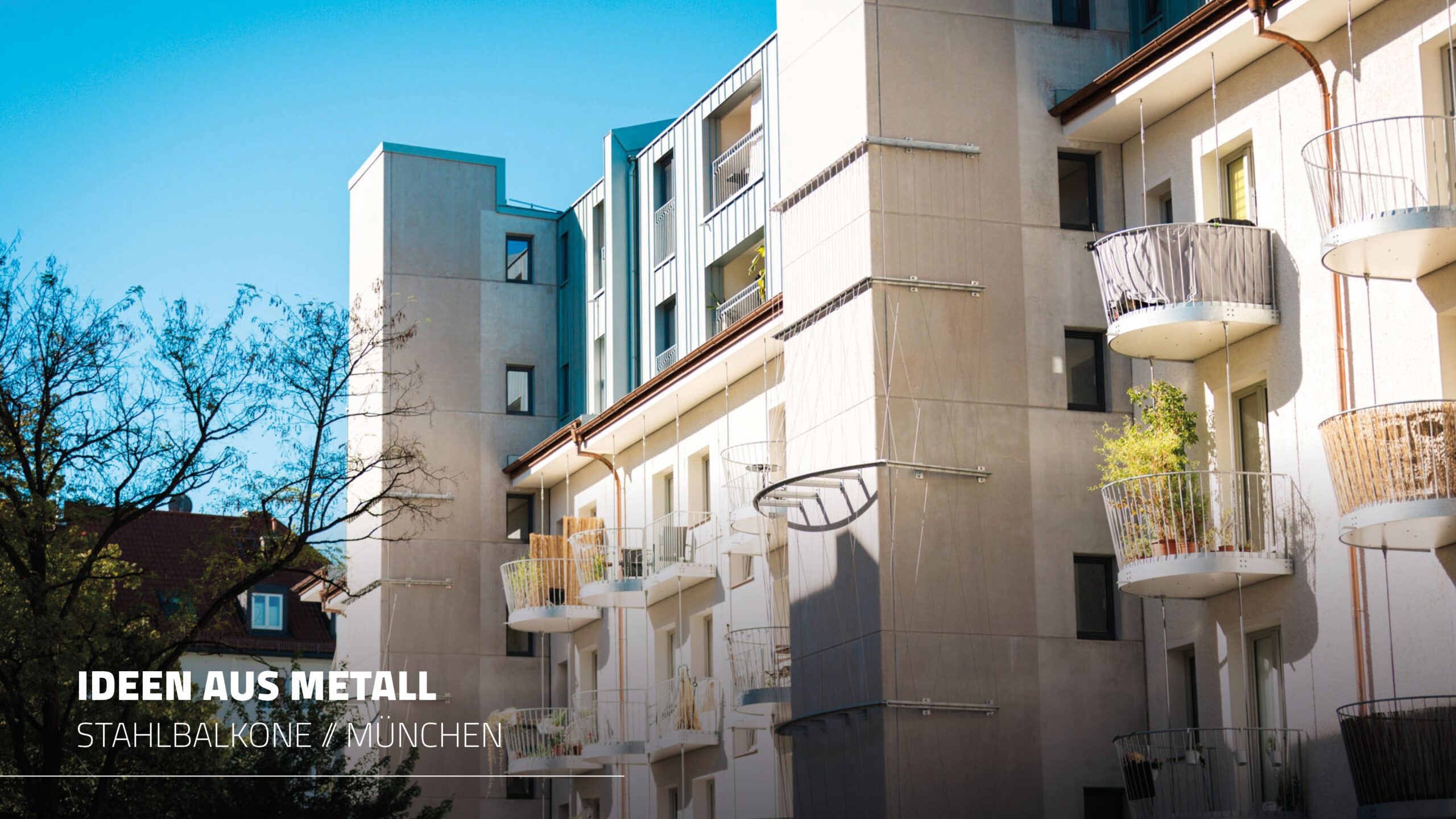 Mehrere Reihen runder Stahlbalkone mit unterschiedlichen Sichtschutzelementen an der hellen Wohnhausfassade, ergänzt durch einen turmartigen Anbau mit Fassadenbegrünungselementen (Rankhilfen).