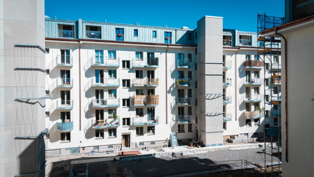 Weitwinkelaufnahme des gesamten neu sanierten Wohngebäudes von der Straßenebene.