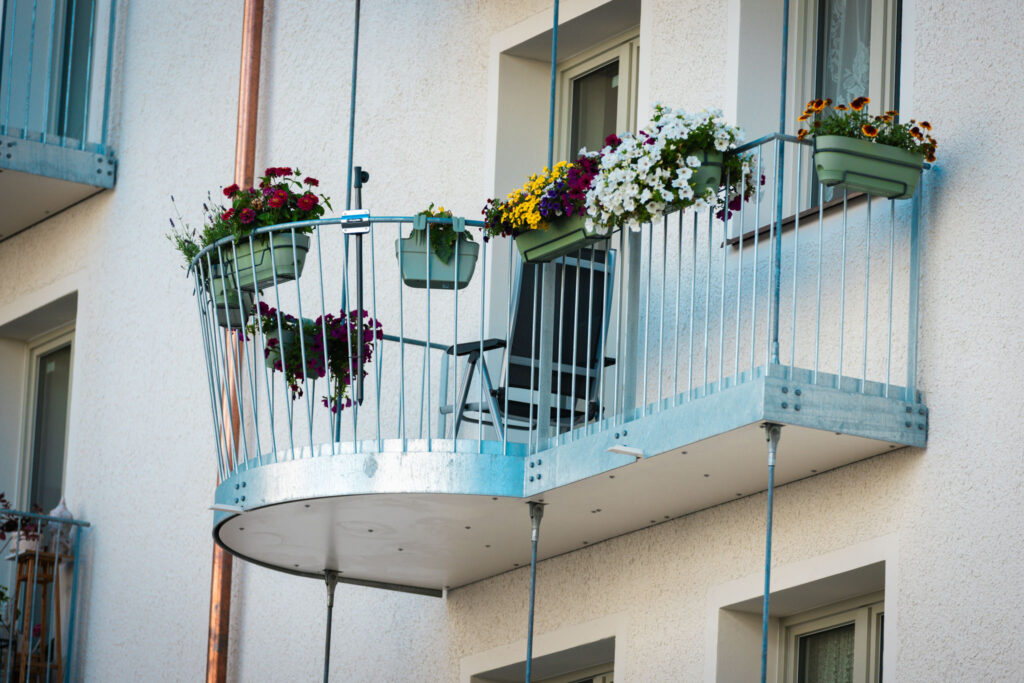 Runder Balkon mit Blumenkästen Nahaufnahme Sanierung Wohngebäude München