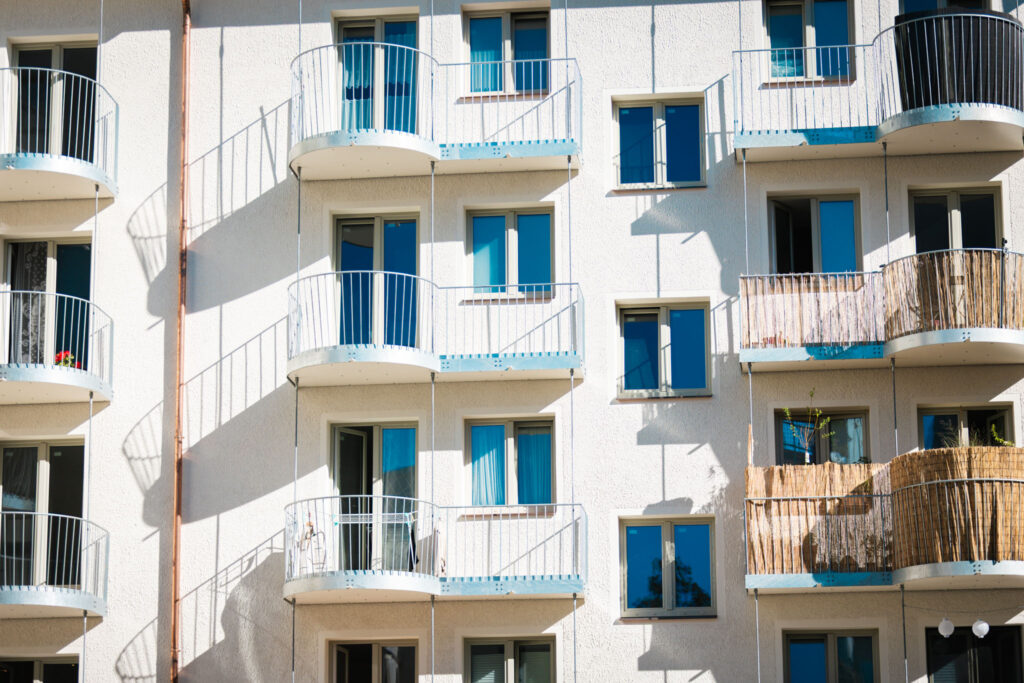 Detail eines Fassadenabschnitts mit mehreren neuen, weißen Balkonen.