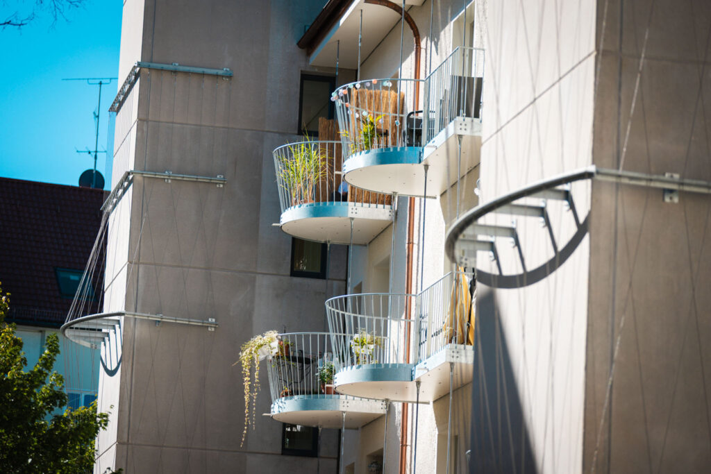 Fassadenturm mit integrierten runden Balkonen und Rankhilfen für Begrünung