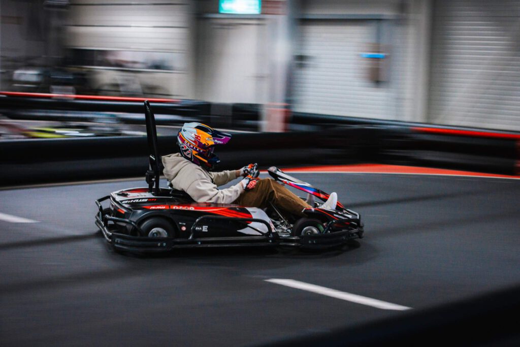Action-Shot: Ein Kart in Schräglage beim Durchfahren einer Haarnadelkurve während der Metallbau-Weihnachtsfeier.