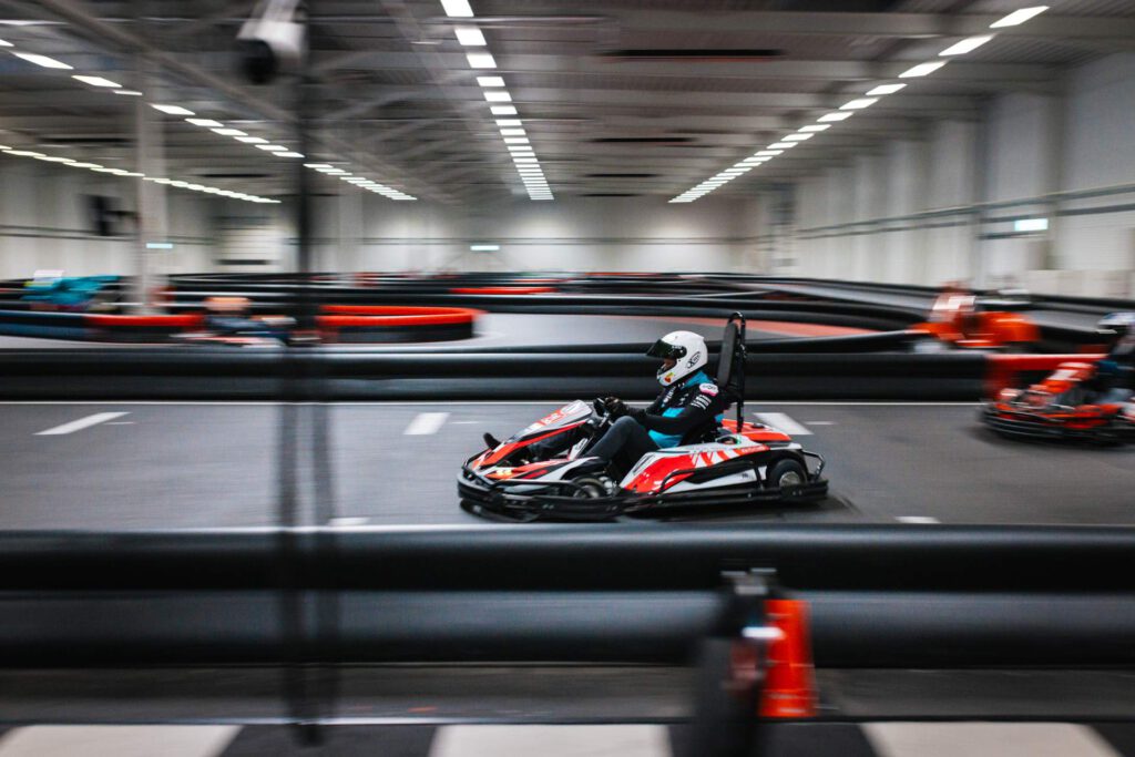 Aufnahme von Dirk Maltitz im Kart während einer rasanten Kurvenfahrt auf der Indoor-Rennstrecke.