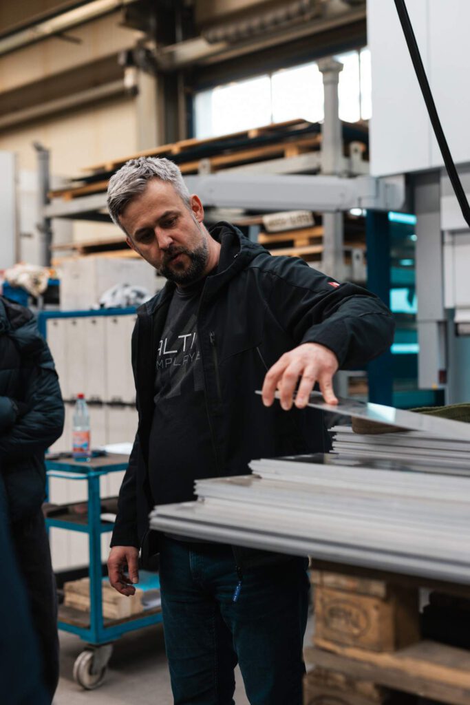 Praxisnahe Einblicke: Alexander Fritzsch prüft gemeinsam mit Schülern die Qualität von lasergeschnittenen Bauteilen in der Werkstatt.