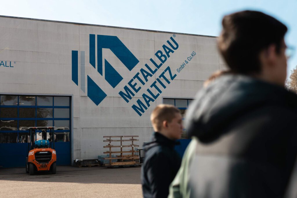 Außenansicht des Firmengebäudes von Metallbau Maltitz mit Firmenlogo während der Woche der offenen Unternehmen, besucht von Schülern im Rahmen der Aktion „Schau rein!“.