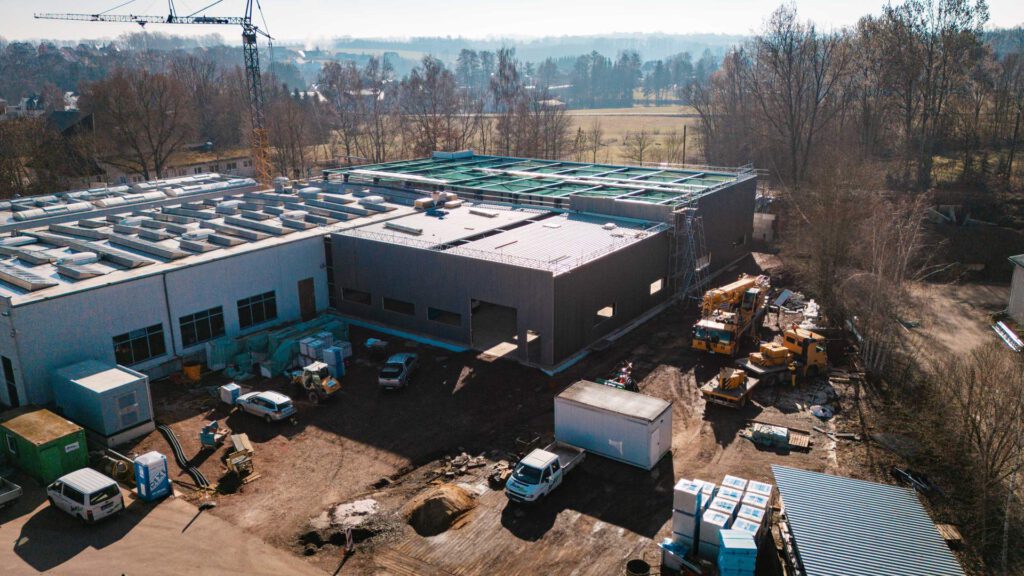 Drohnenaufnahme der Großbaustelle: Die Verbindung von Bestandshallen und dem neuen Hallenbau-Projekt.