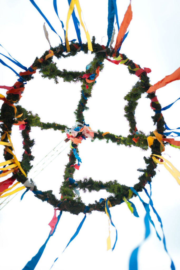 Die bunte Richtkrone symbolisiert den Abschluss der Rohbauphase und den Erfolg über den Frost der Vormonate.