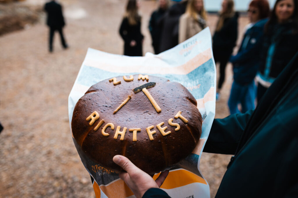 Traditionelles Richtfest-Brot als Symbol für den rasanten Baufortschritt am neuen Sozialtrakt und den Hallen.
