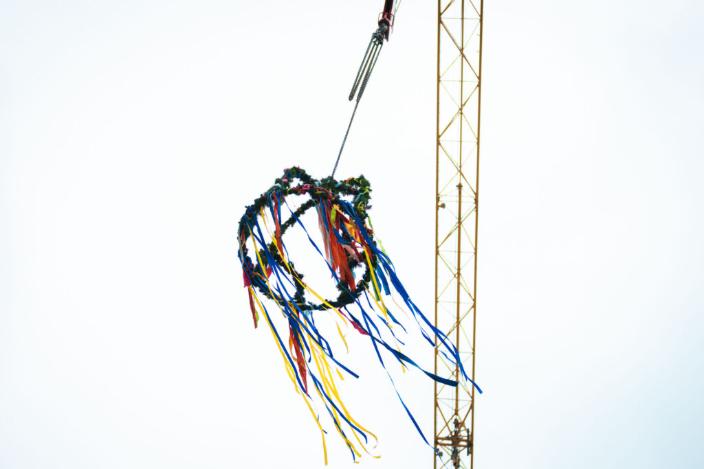 Die Richtkrone am Kran über den nun wetterfesten Hallen – bereit für den Innenausbau und neue Maschinen.