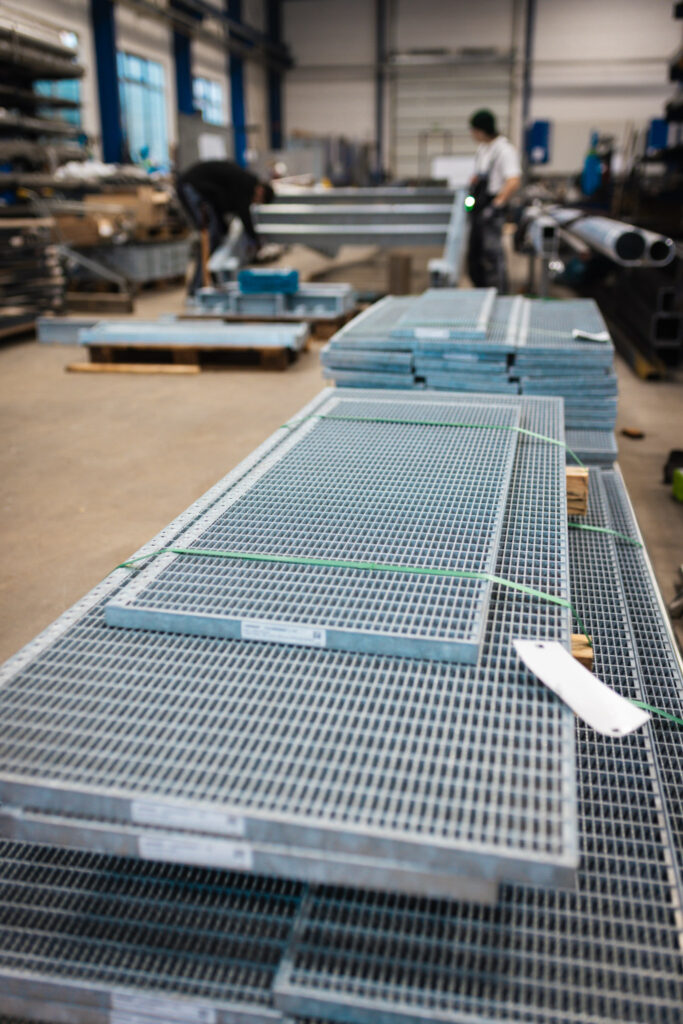 Stapel von robusten Gitterrost-Stufen, die für die Trittsicherheit der neuen Außentreppen sorgen.