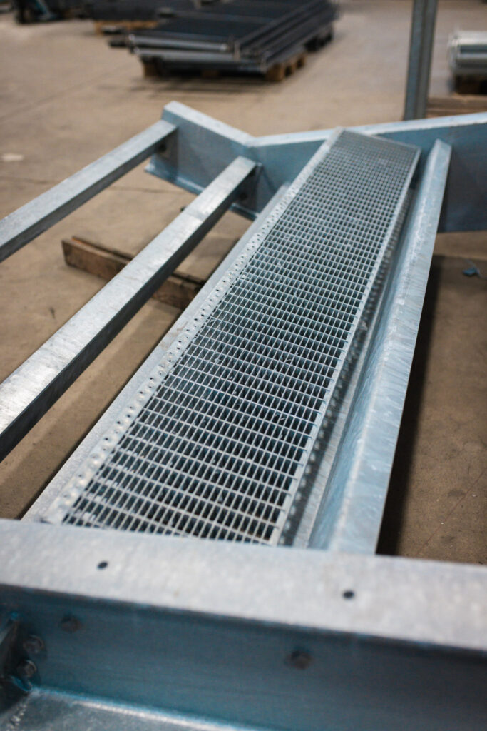 Detailaufnahme einer in die Treppenwange eingelegten Gitterroststufe – bereit für die finale Montage.