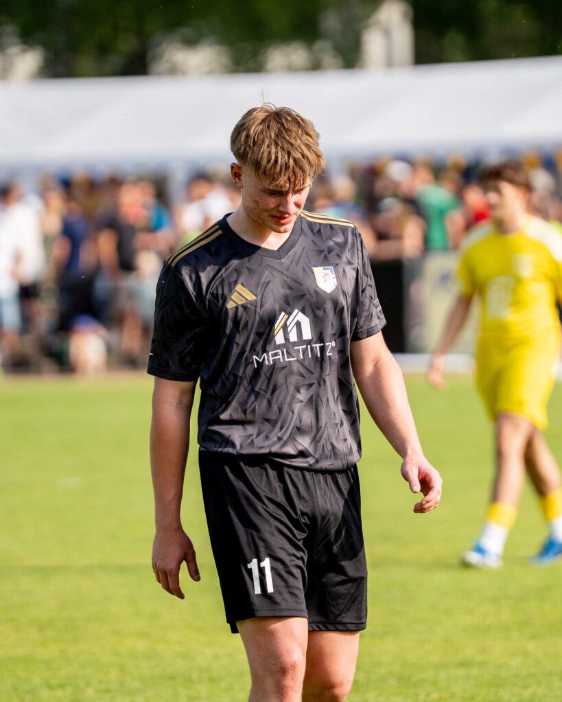 Spieler des SV Waldenburg 1844 e.V. präsentiert das neue schwarze Sponsoring-Trikot von Maltitz Metallbau.