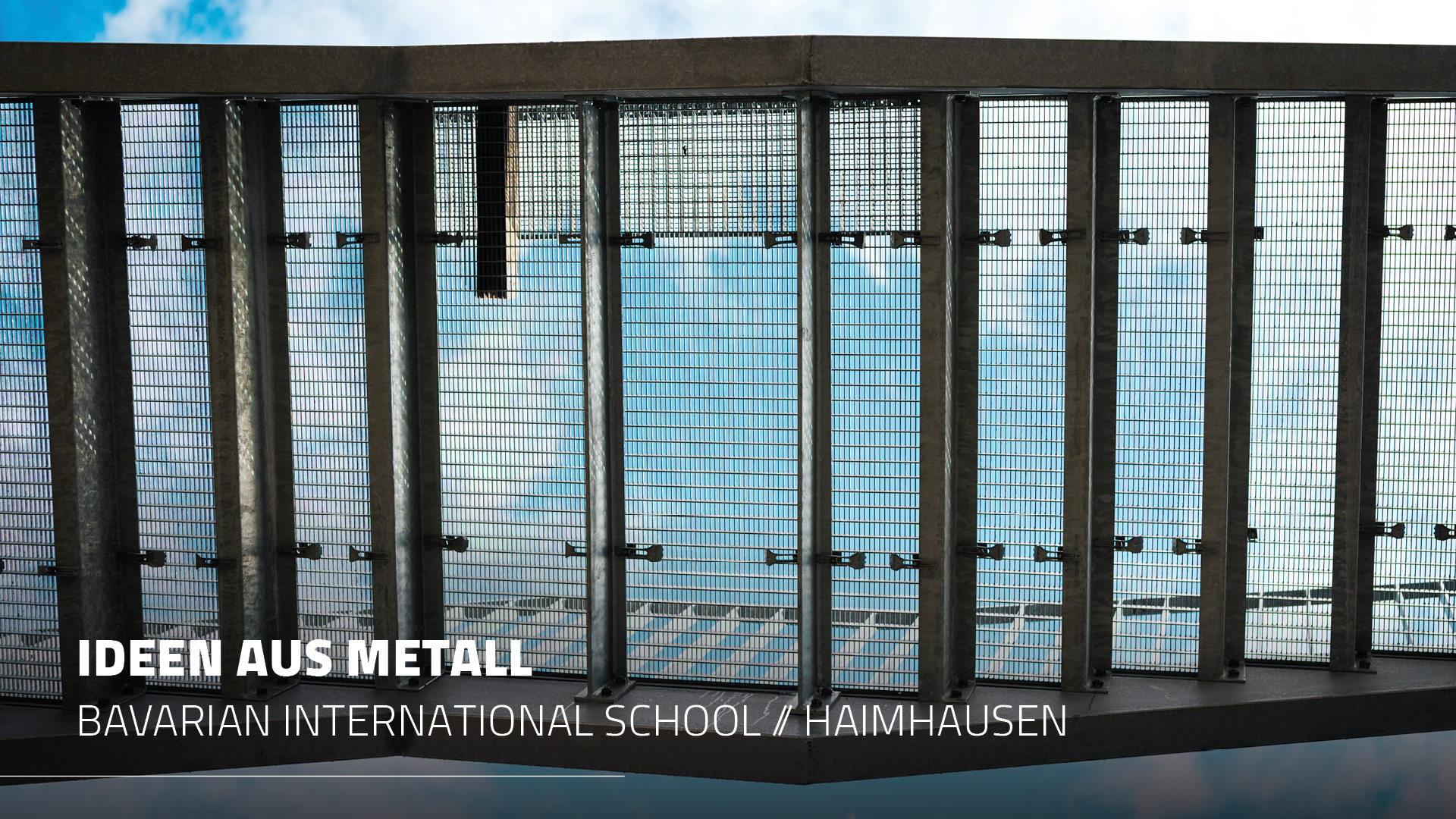 Blick von unten durch die aufgelegten Gitterroste des feuerverzinkten Fluchtbalkons von Metallbau Maltitz an der Bavarian International School in Haimhausen.