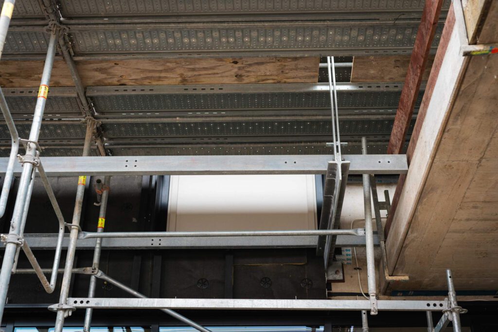 Unterseite eines Fluchtbalkons aus Stahl an der Bavarian International School, abgehängt mit Konsolen an der Fassade.