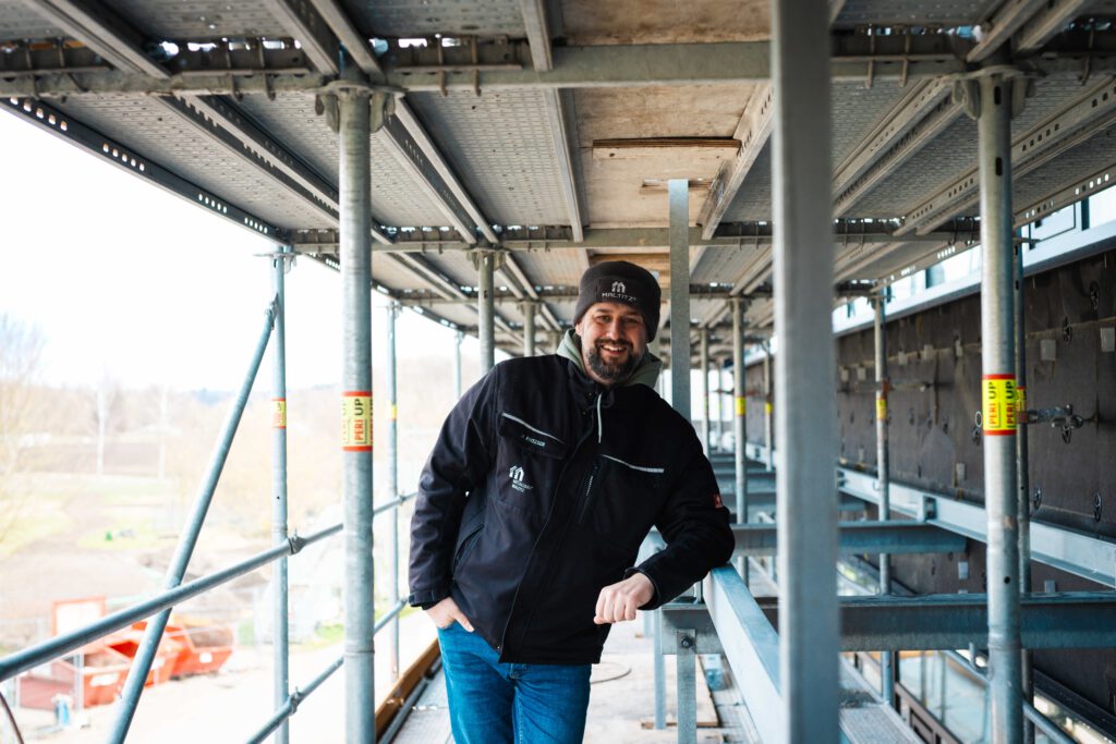 Projektleiter Alexander Fritzsch leht am Gerüst der Bavarian School.