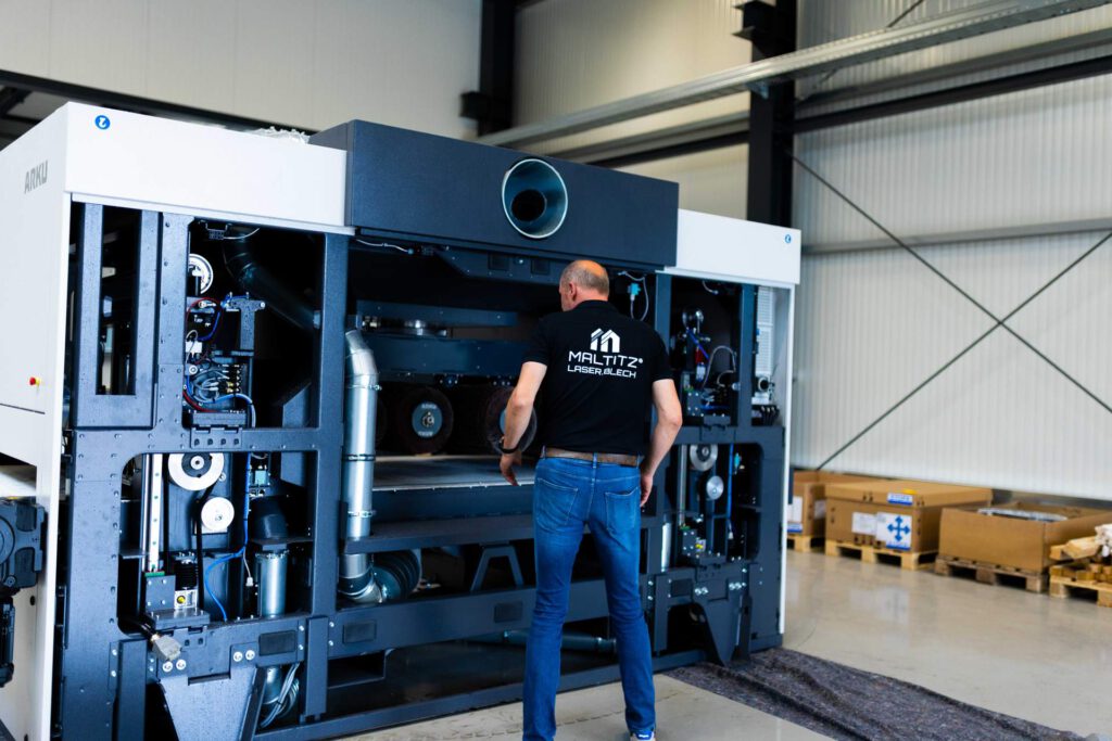 Geschäftsführer Dirk Maltitz berachtet die neue ARKU Entgratmaschine.