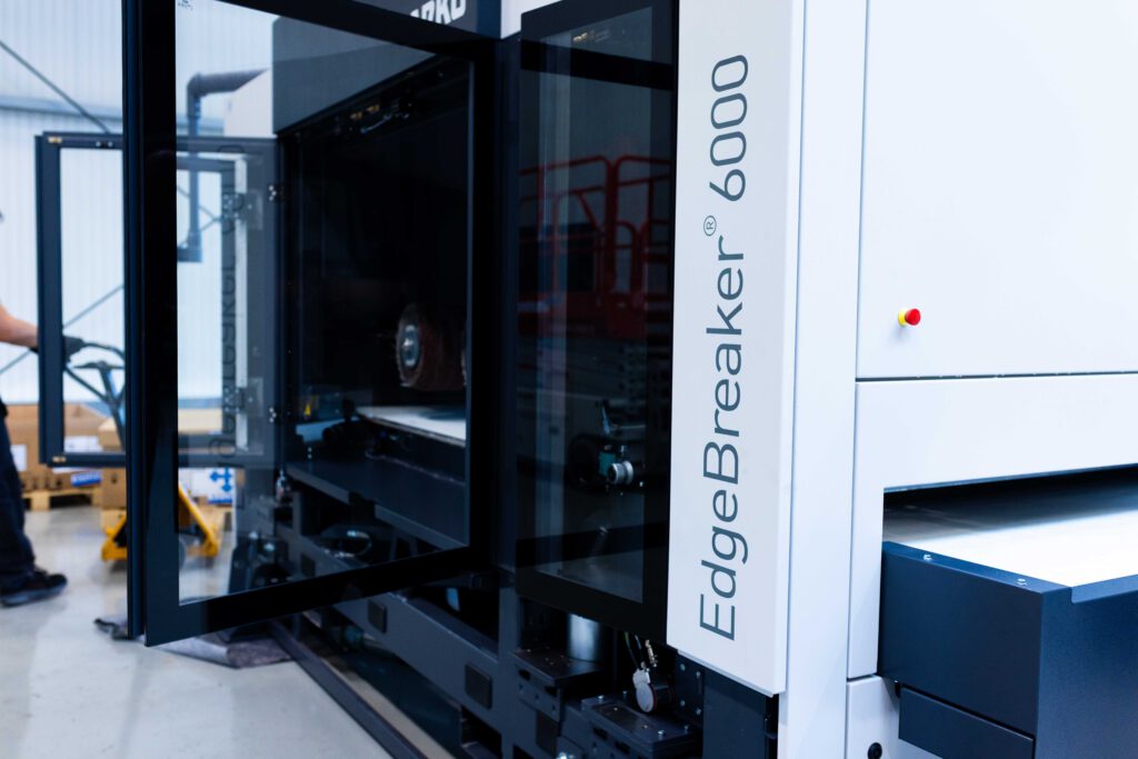 Nahaufnahme der geöffneten Glastür der ARKU EdgeBreaker 6000 Blechbearbeitungsmaschine.
