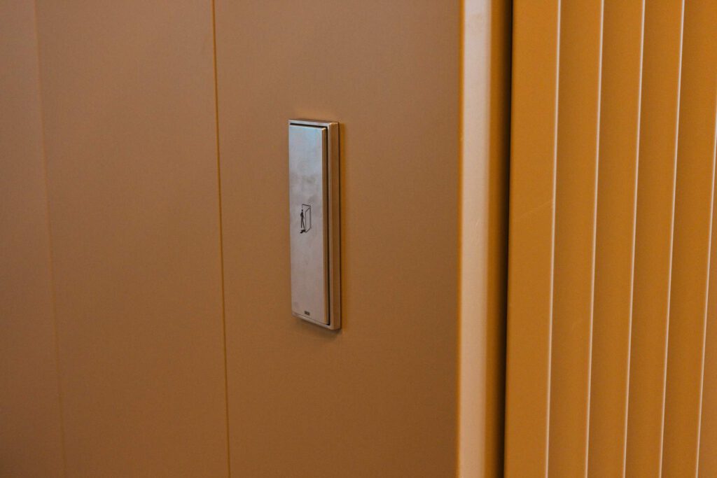 Detail der hochwertigen Metallverkleidung mit integriertem Bedienelement im Eingangsbereich der Meiller Gärten München