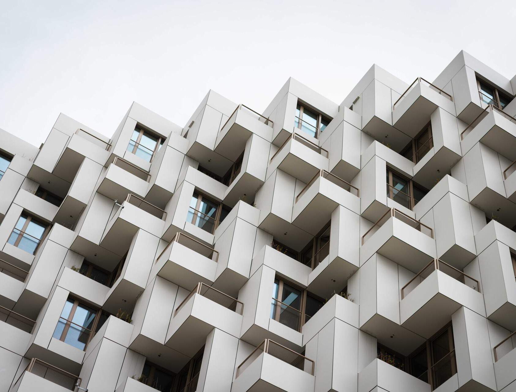 Außenansicht der modernen Wohnanlage Meiller Gärten in München mit markanter Fassade, Balkonen und Metallbauelementen