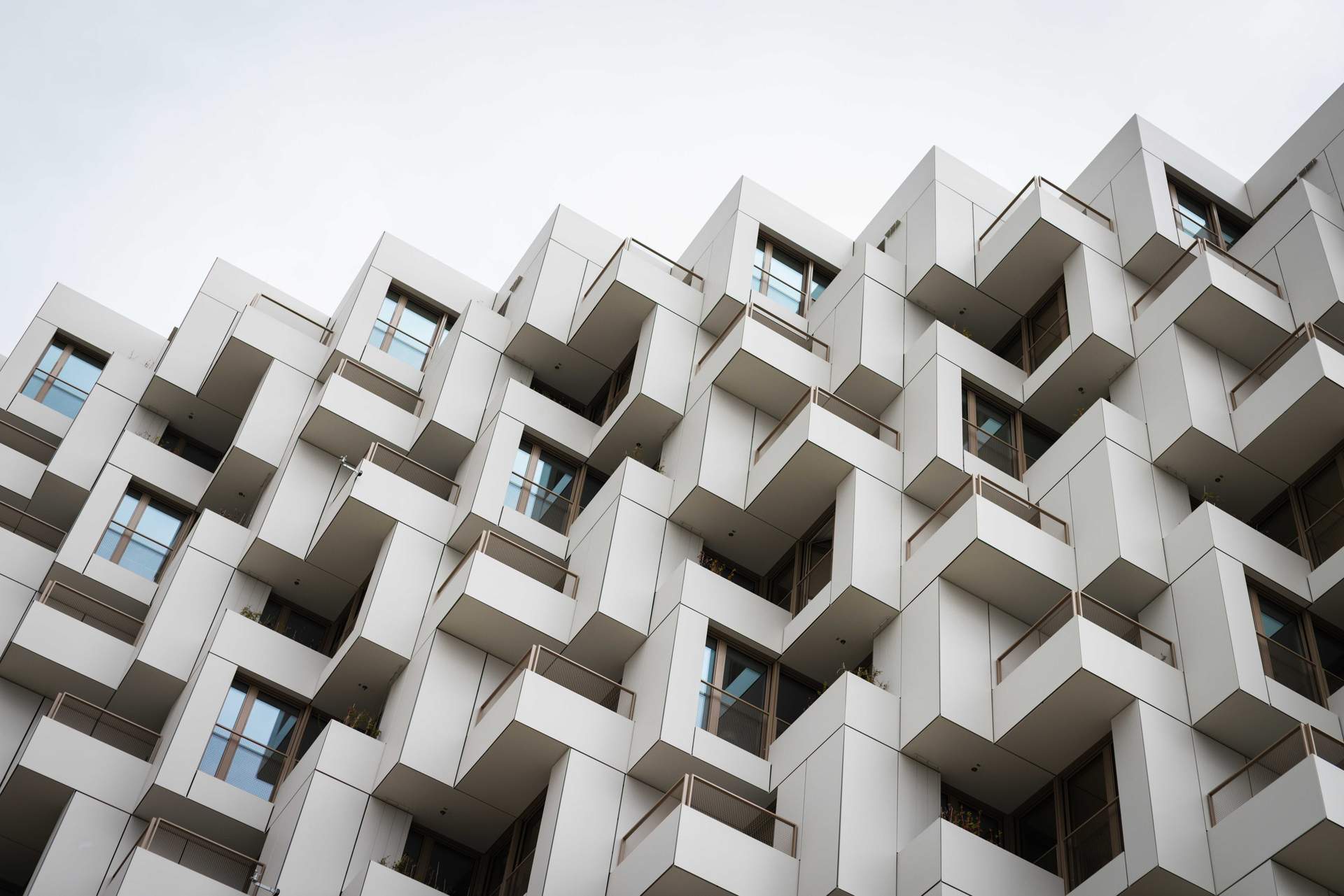 Außenansicht der modernen Wohnanlage Meiller Gärten in München mit markanter Fassade, Balkonen und Metallbauelementen