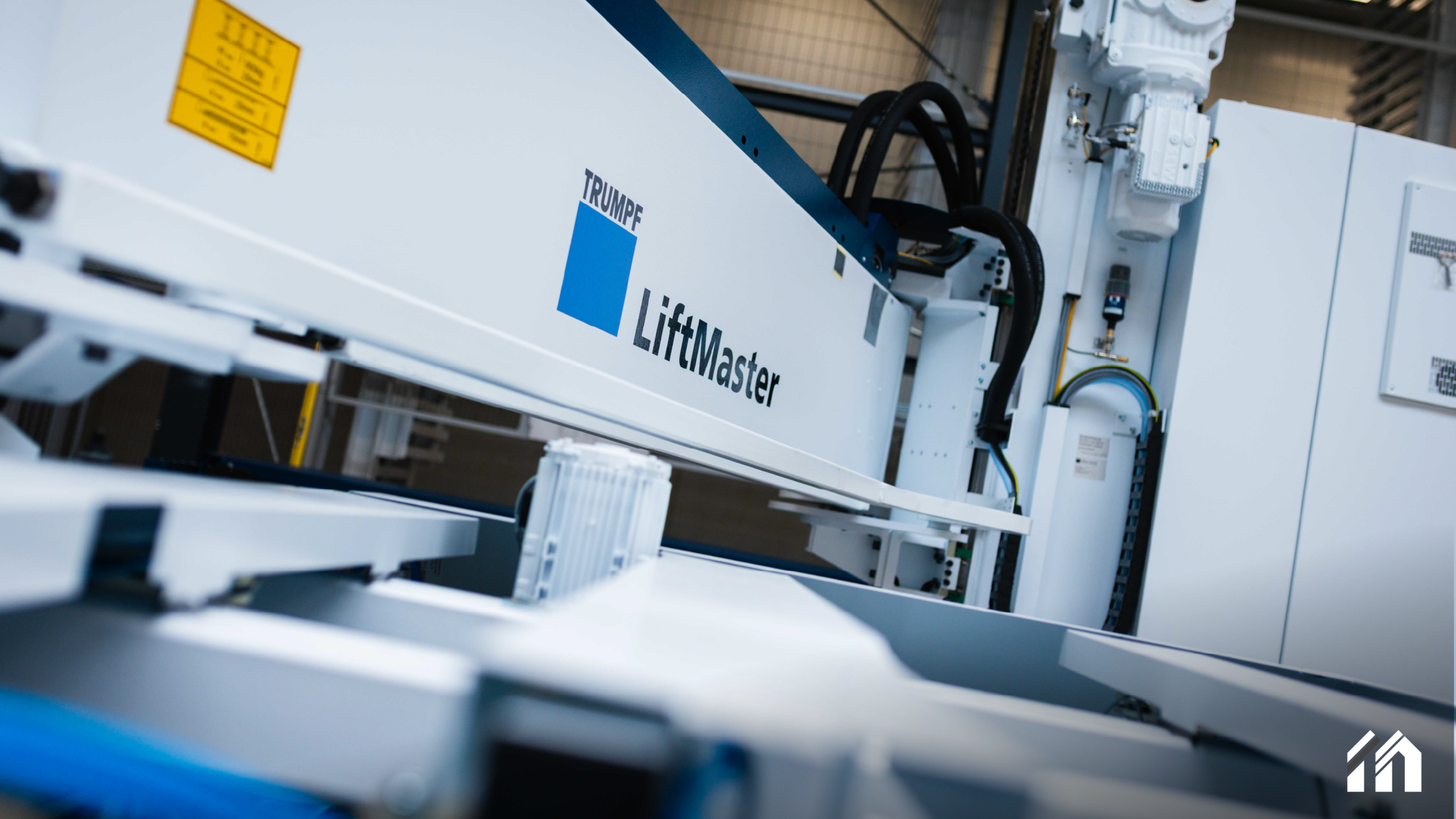 chräge Nahaufnahme einer modernen Industriemaschine der Marke TRUMPF mit der Aufschrift „LiftMaster“ und blauem Logo in einer hellen Fabrikumgebung.