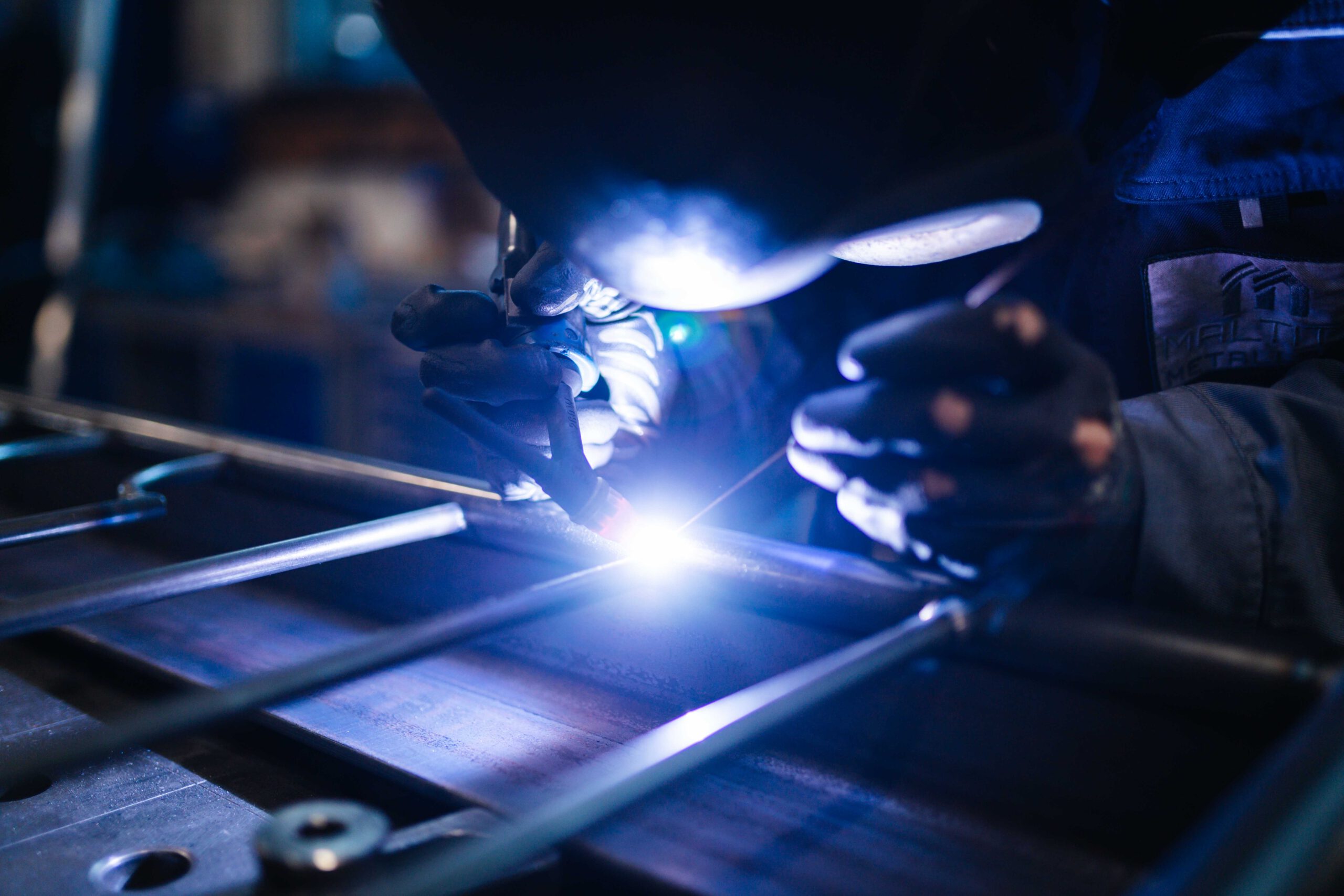 Metallarbeiter bzw. Schweißer führt präzise WIG-Schweißarbeiten an Metallrohren in einem Industriebetrieb aus.